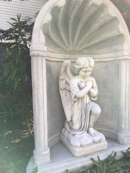 Mooi knielend engelbeeld vol steen in bidkapel vol steen.